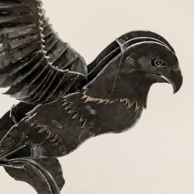 Close detail of the eagle’s head and layered metal feathers