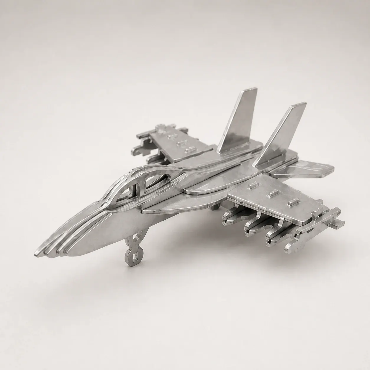 Studio visual of the silver-toned layered fighter aircraft object